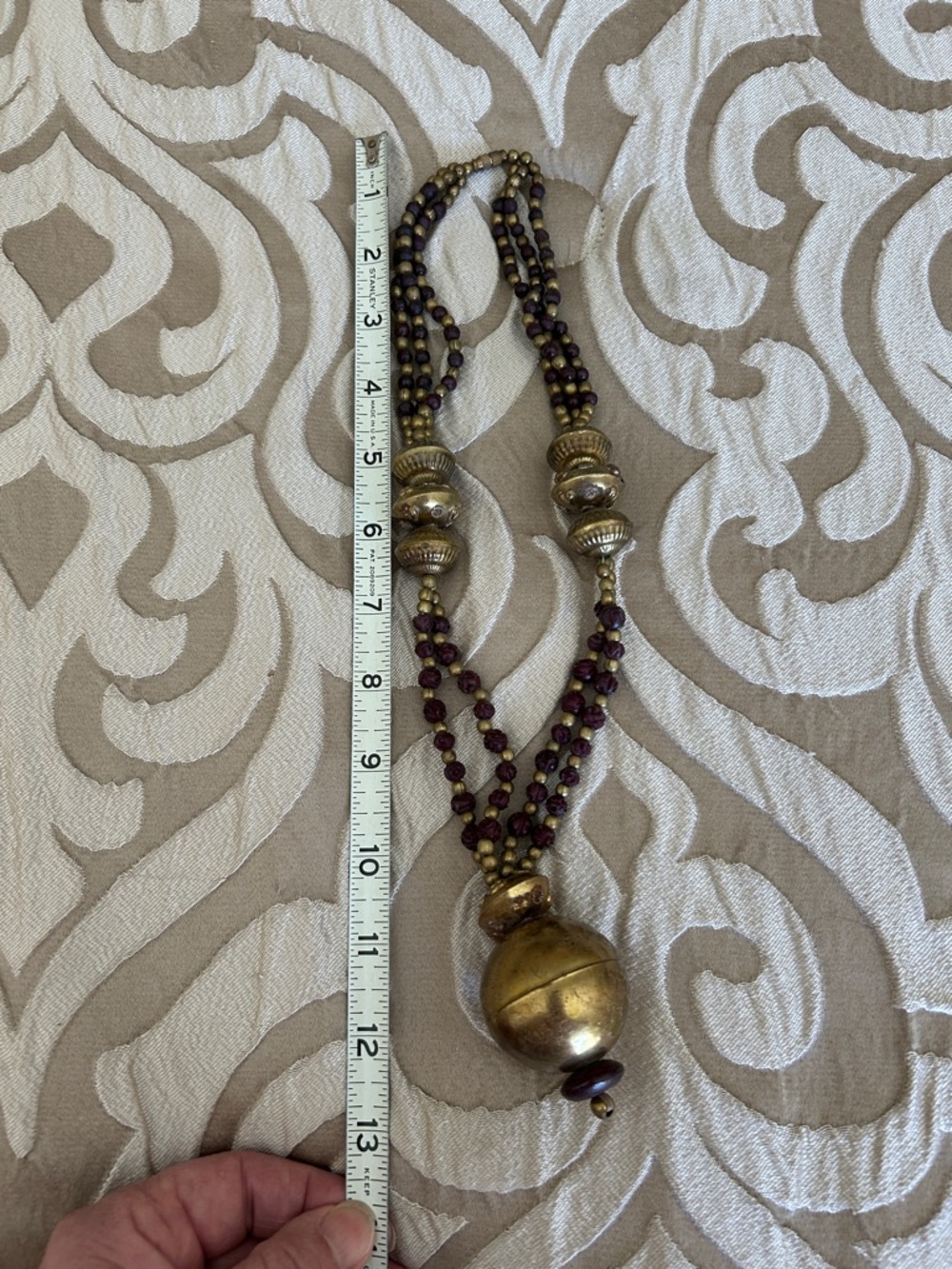Brass necklace with deep burgundy beads.